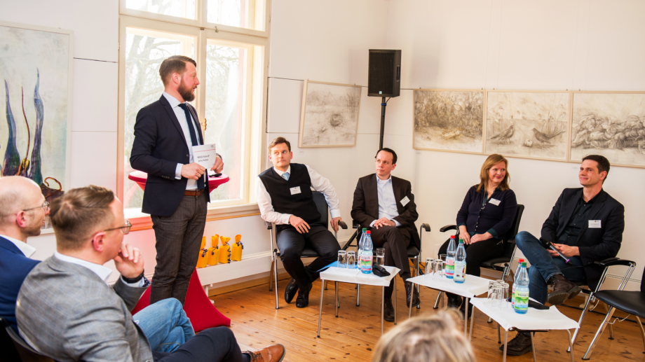 Quelle: JenaKultur, Foto: Christoph Worsch Teilnehmer verfolgen die Podiumsdiskussion und die Ansagen des Moderators